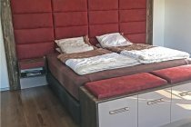 Schlafzimmer mit Boxspringbett und angrenzendem Ankleideraum